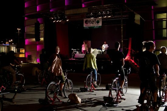 Foto vom Ars Electronica Maindeck beim Ars Electronica Festival 2011, GelbGut spielt auf der Bühne, während RadfahrerInnen mit Dynamos für Strom sorgen